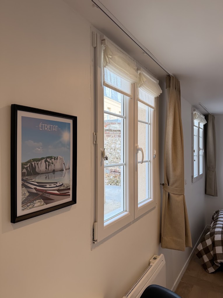 Fenêtre avec vue et affiche d'Étretat